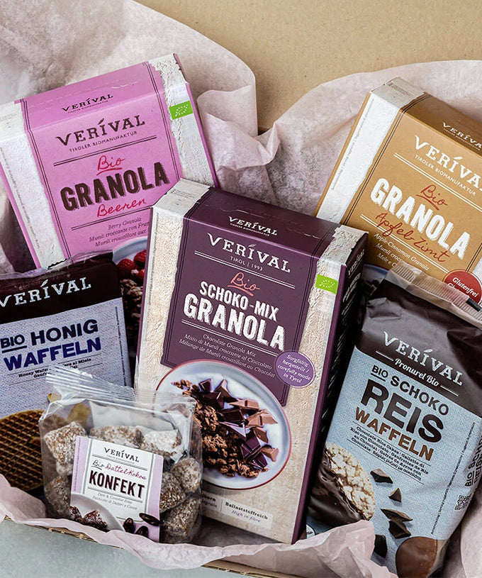 Genießen Sie gute Laune mit diesem Geschenkset von Verival Bio GmbH: Müsli, Schokoladen-Müsli-Mischung, Reis-Honig-Waffeln und Schokoladenkonfekt – alles in einer mit Seidenpapier ausgekleideten Schachtel. Perfekt für ein köstliches Bio-Frühstück!.